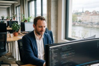 Consultant informatique professionnel travaillant sur des écrans dans un bureau moderne à Lyon